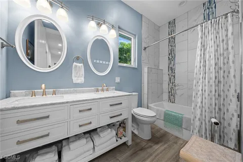 a bathroom with a granite countertop toilet a sink and a mirror