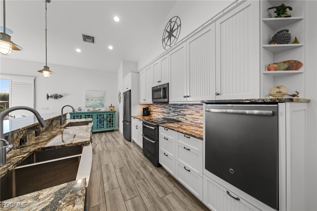 2743 Janet Street Matlacha, FL 33993 - Photo 19 of 45 a kitchen with stainless steel appliances granite countertop a stove a sink and a refrigerator