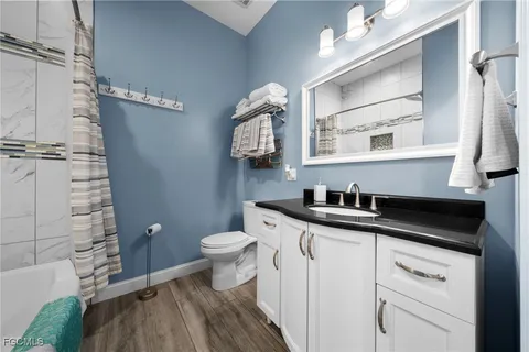 a bathroom with a granite countertop sink a toilet and a mirror