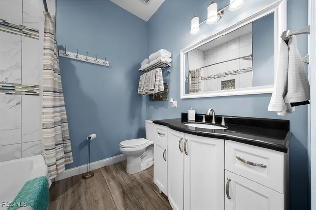 a bathroom with a granite countertop sink a toilet and a mirror