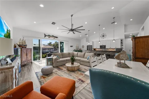 a living room with furniture kitchen view and a large window