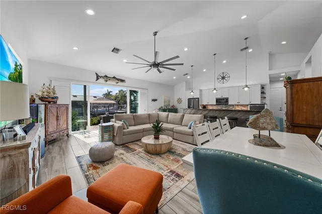 a living room with furniture kitchen view and a large window