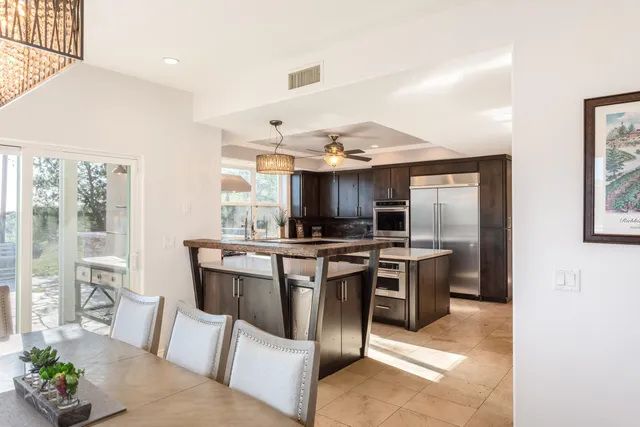 a kitchen with kitchen island granite countertop a sink stainless steel appliances and counter space
