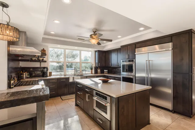 a kitchen with stainless steel appliances granite countertop a stove refrigerator and cabinets