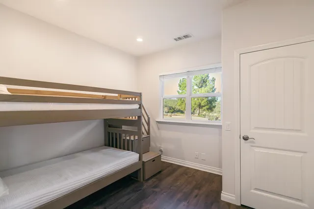 a bedroom with a large bed a chandelier and dresser
