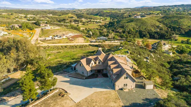 an aerial view of residential houses with outdoor space and trees