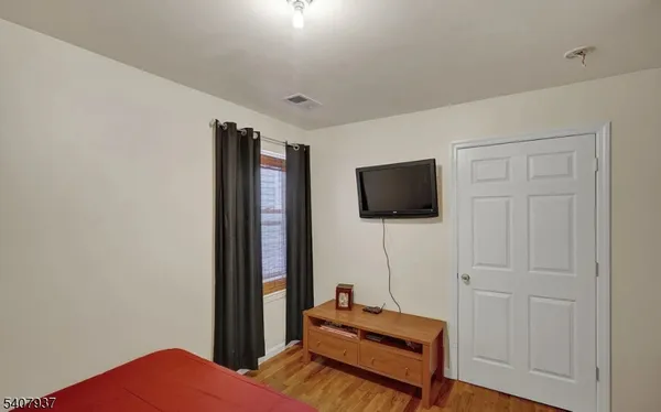a bedroom with bed and flat screen tv