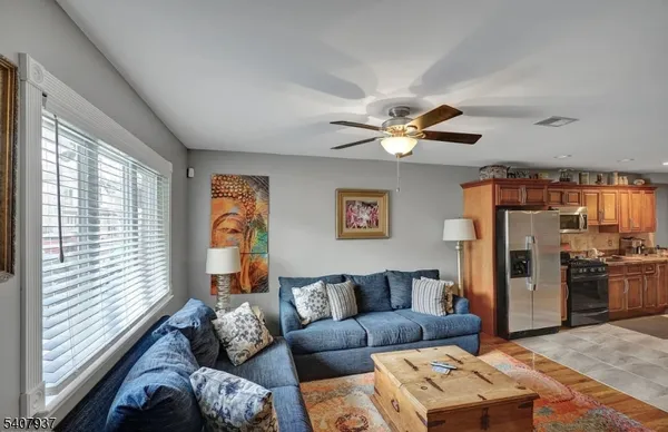 a living room with furniture ceiling fan and a window