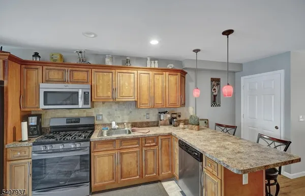 a kitchen with stainless steel appliances granite countertop a stove sink and cabinets