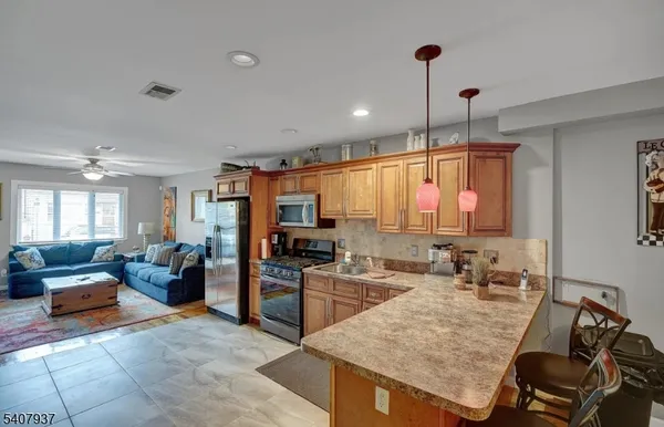 a large kitchen with kitchen island granite countertop a sink counter space appliances and furniture