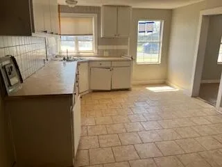 a kitchen with granite countertop a sink a stove a refrigerator and cabinets