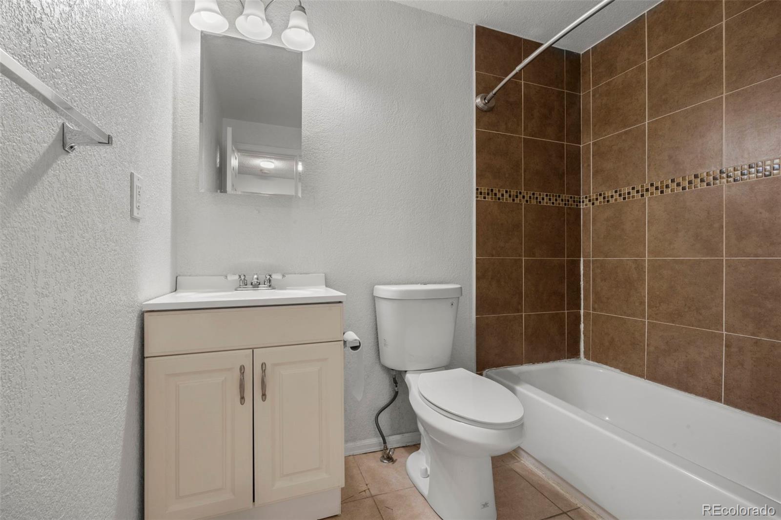 5167 Sable Street Denver, CO 80239 - Photo 12 of 27 a bathroom with a sink toilet and shower