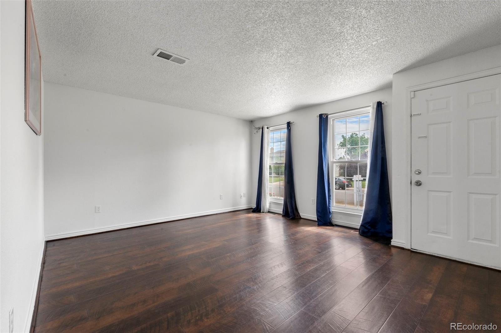 5167 Sable Street Denver, CO 80239 - Photo 7 of 27 a view of a livingroom with wooden floor and a window