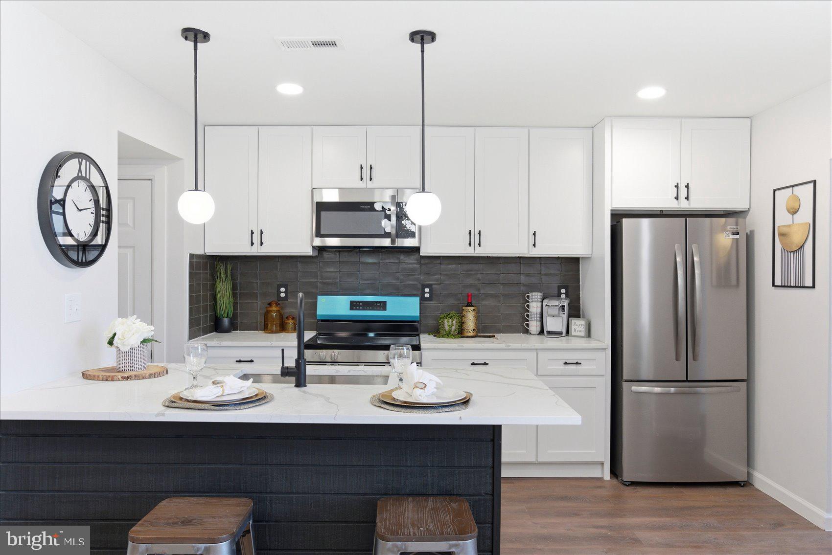 2009 Ruxton Avenue Baltimore, MD 21216 - Photo 13 of 37 a kitchen with stainless steel appliances a refrigerator a sink a stove and a wooden floors