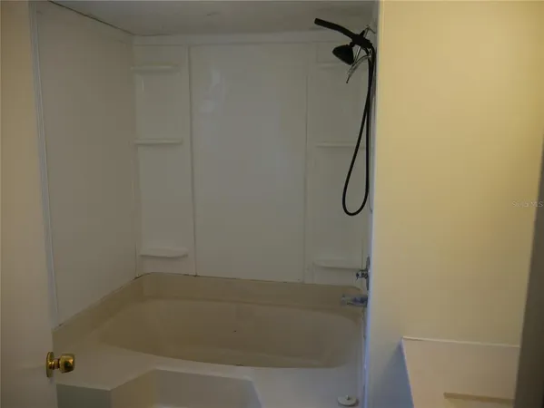 a bathroom with a bath tub with a shower