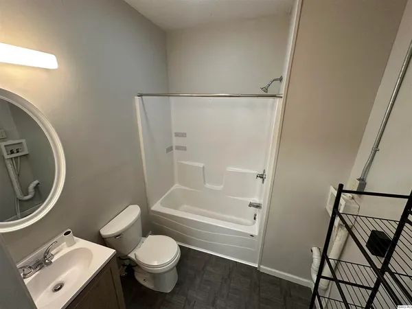 a white toilet sitting next to a bathroom sink and a shower