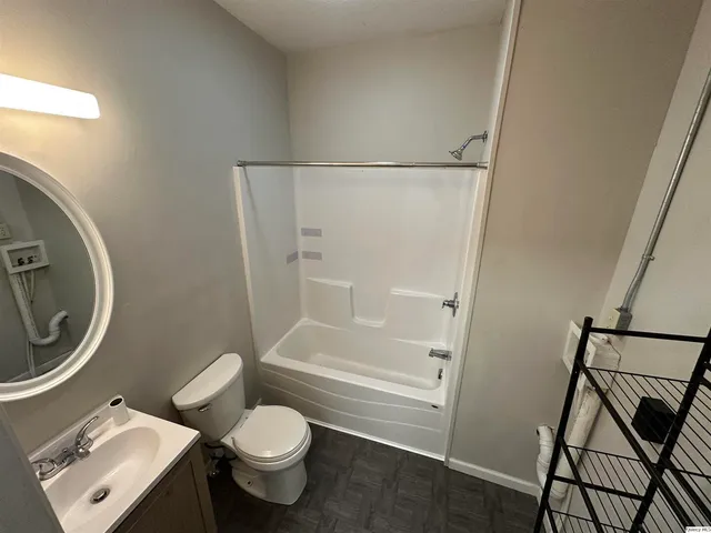a white toilet sitting next to a bathroom sink and a shower