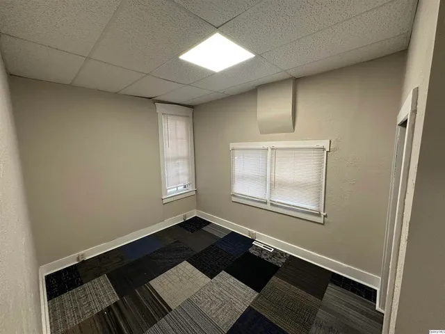 an empty room with windows and wooden floor