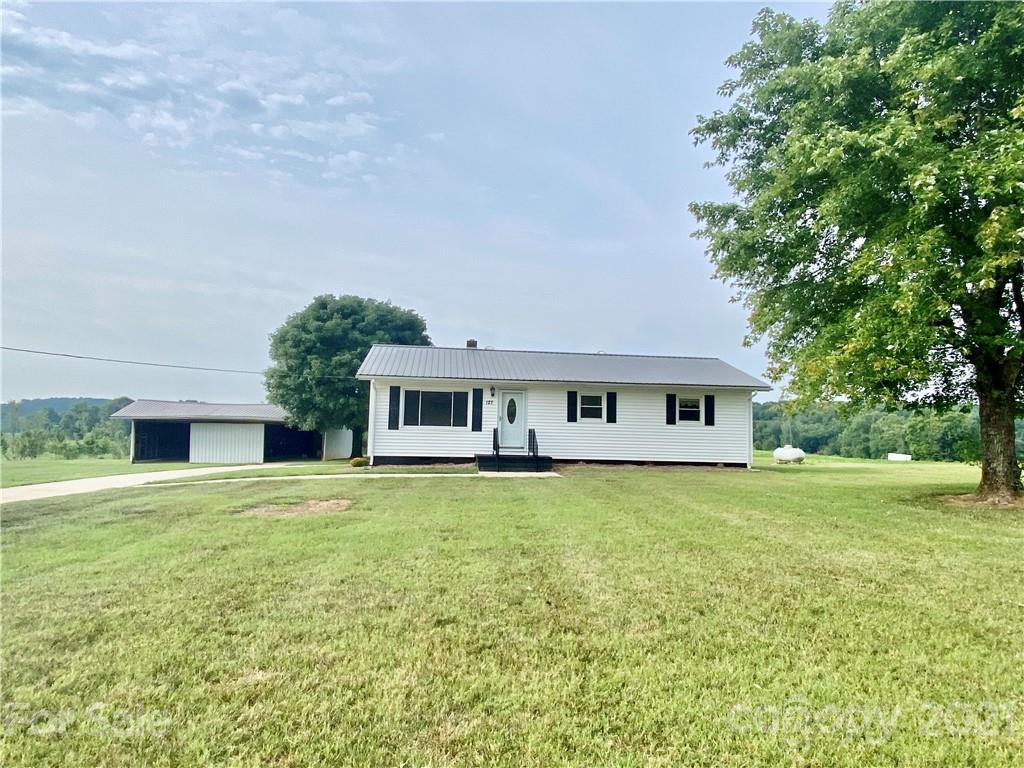 127 Countryside Road Harmony, NC 28634 - Photo 1 of 27 a house that has a big yard with large trees