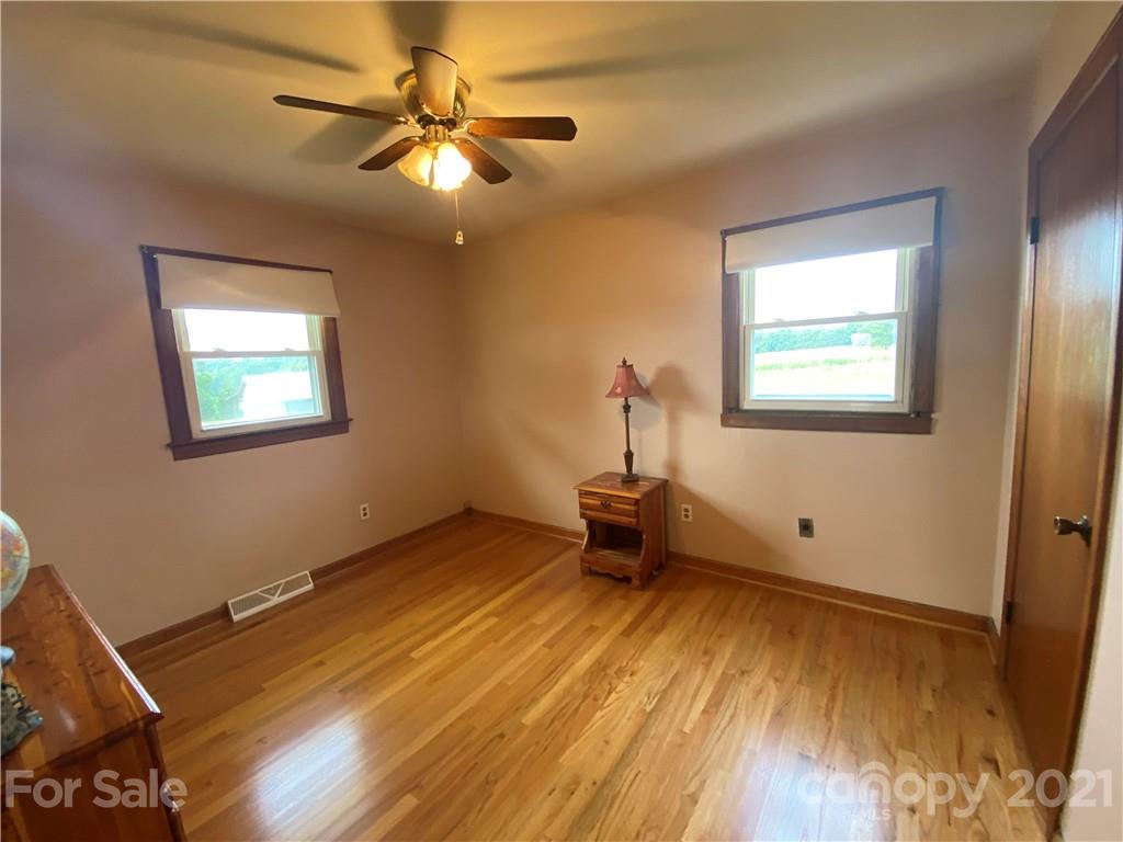 127 Countryside Road Harmony, NC 28634 - Photo 17 of 27 a view of an empty room with a window and wooden floor