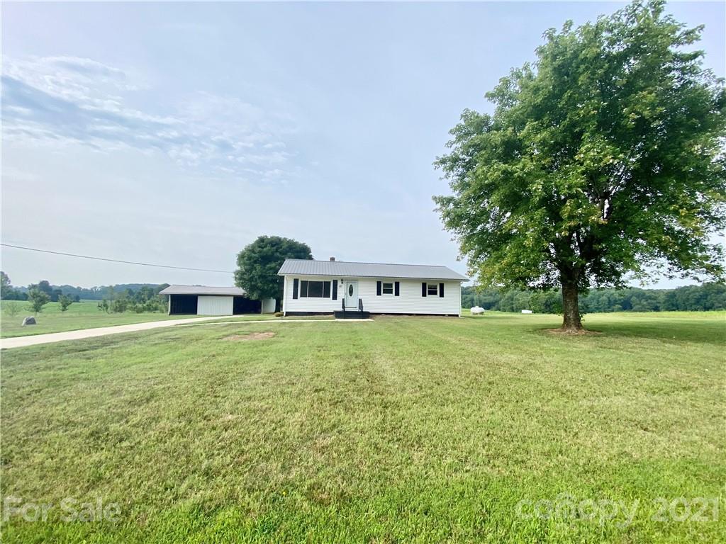 127 Countryside Road Harmony, NC 28634 - Photo 27 of 27 a house with huge green field and large trees