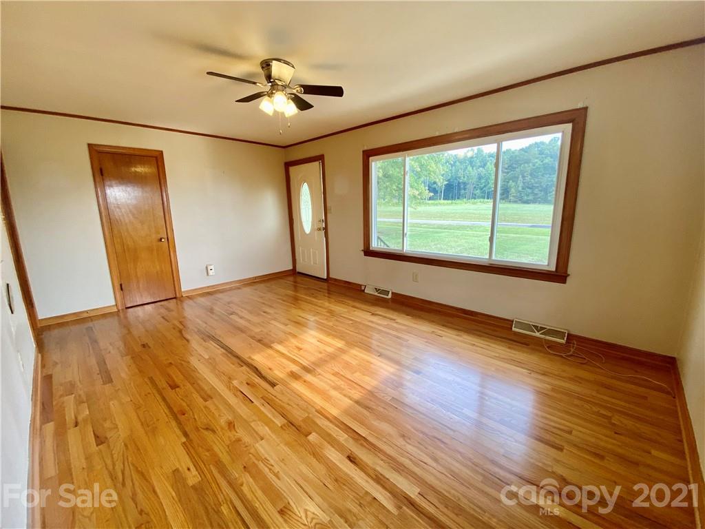 127 Countryside Road Harmony, NC 28634 - Photo 6 of 27 a view of an empty room with a window and wooden floor