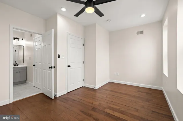 an empty room with wooden floor and mirror