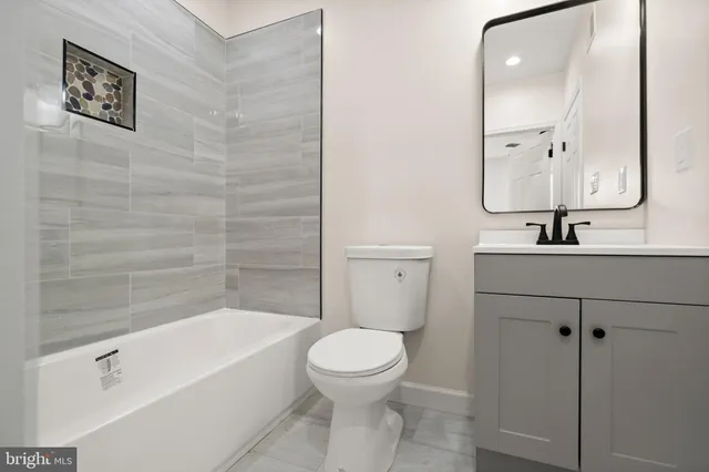 a bathroom with a bathtub shower sink mirror and toilet