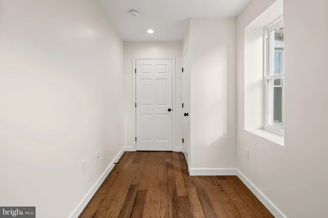 a view of a room with wooden floor and a window