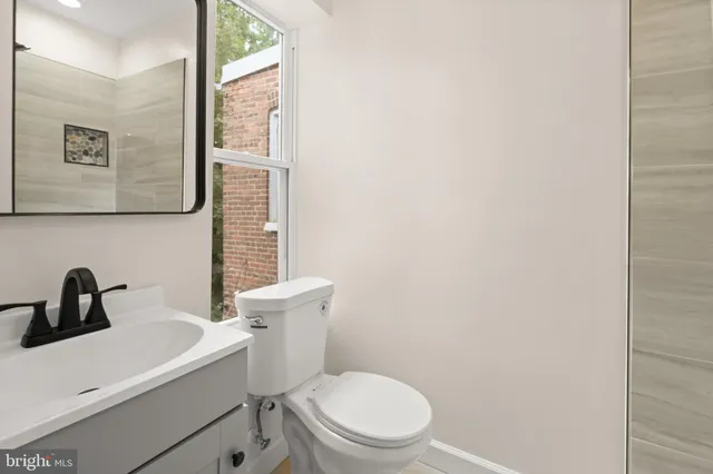a bathroom with a toilet sink and mirror