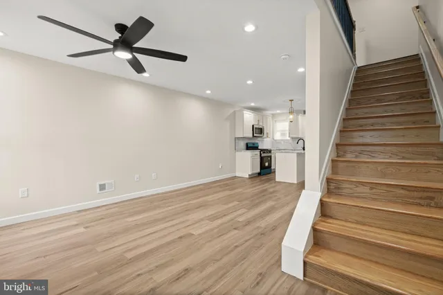 wooden floor in an empty room with wooden floor and a ceiling fan