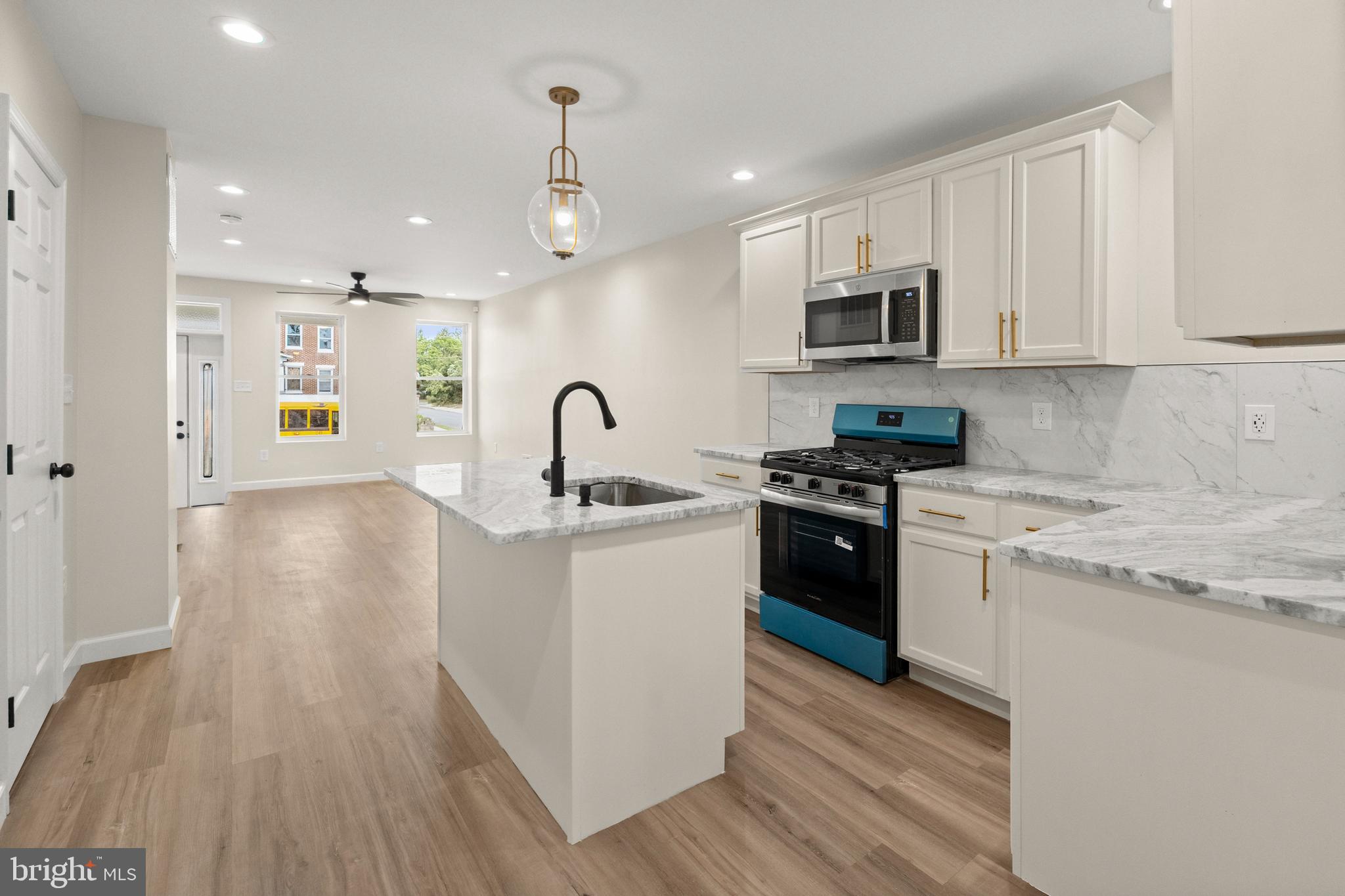 2815 West Cold Spring Lane Baltimore, MD 21215 - Photo 8 of 37 a kitchen with stainless steel appliances granite countertop a refrigerator a sink dishwasher a stove and white countertops with wooden floor