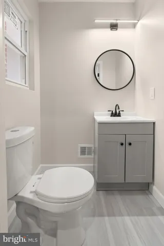 a bathroom with a toilet a sink and mirror
