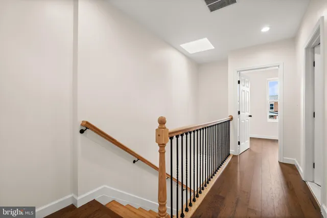 a view of a hallway with wooden floor and staircase