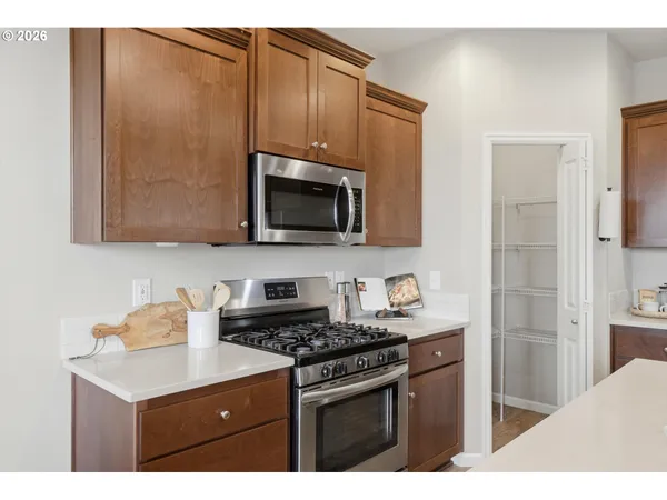 a kitchen with stainless steel appliances a sink a stove a microwave cabinets and a counter top space