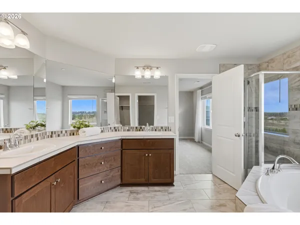 a spacious bathroom with a granite countertop sink mirror and bathtub