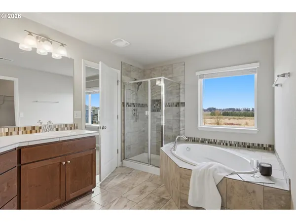 a bathroom with a granite countertop sink mirror and a bathtub