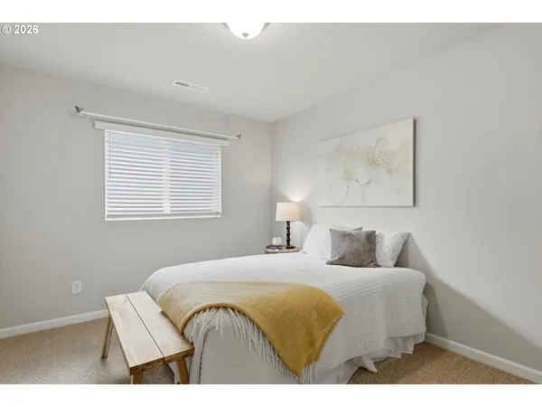 a bedroom with a bed and a painting on the wall