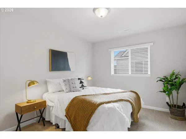 a bedroom with bed and a potted plant