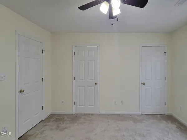 an empty room with a chandelier fan