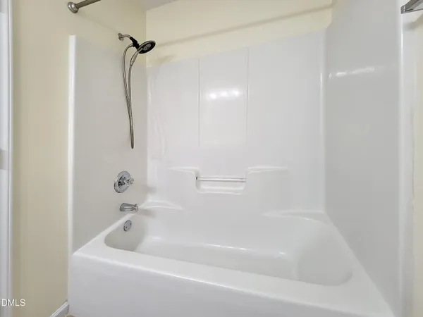 an empty room with a chair and mirror