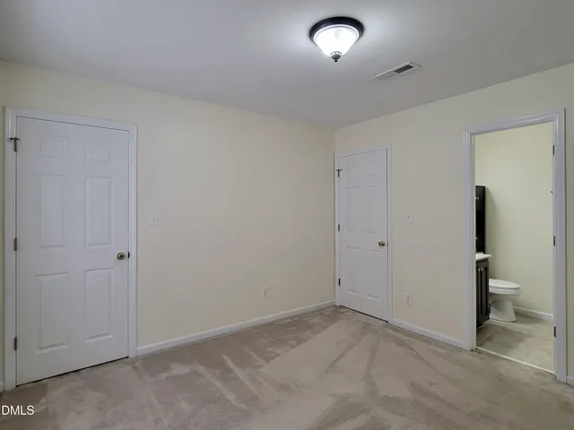 a bathroom with a granite countertop toilet sink and mirror