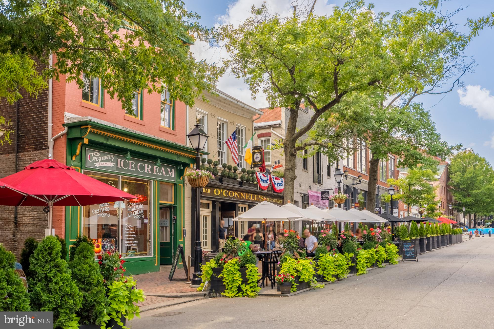 110 Cameron Street, Unit CS102 Alexandria, VA 22314 - Photo 14 of 24 a view of a cafe with a table and chairs under an umbrella