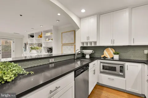 a kitchen with granite countertop a sink a stove and cabinets