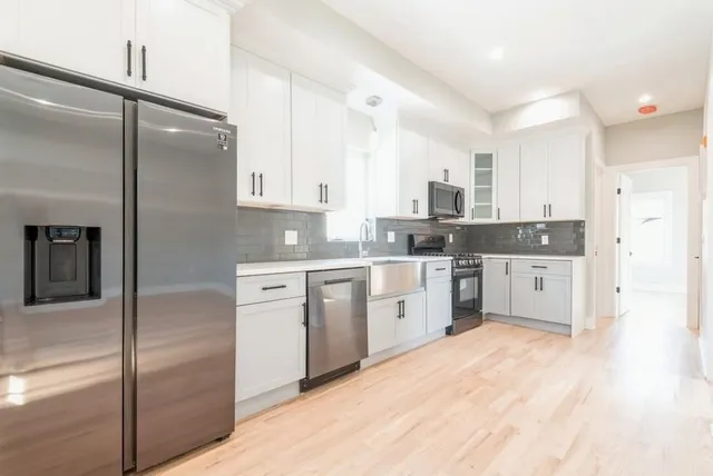 a kitchen with a refrigerator a sink and cabinets