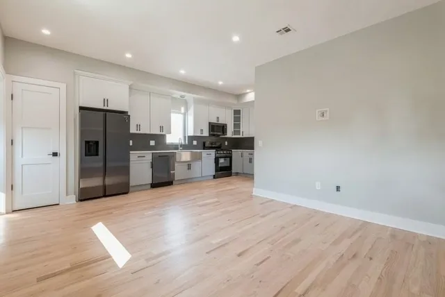 a view of kitchen with wooden floor and electronic appliances