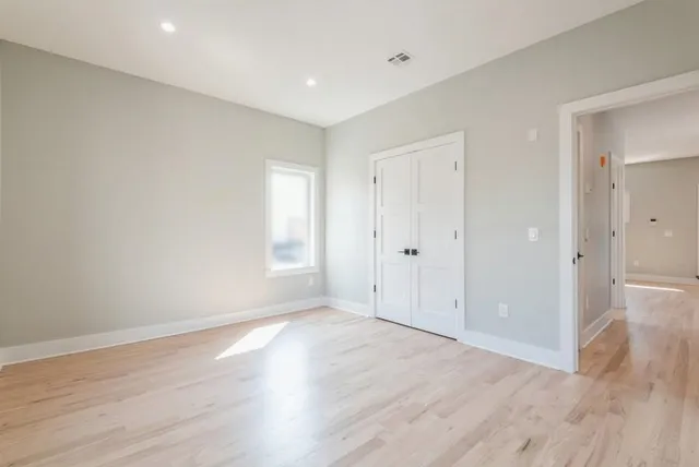a view of an empty room with wooden floor