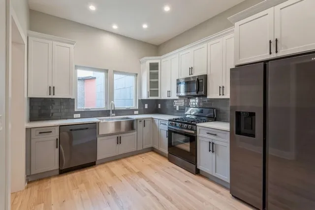 a kitchen with stainless steel appliances granite countertop a refrigerator a stove top oven a sink and dishwasher