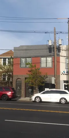 a view of a building and car parked on the road