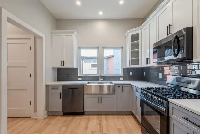 a kitchen with stainless steel appliances granite countertop a stove a sink and a microwave